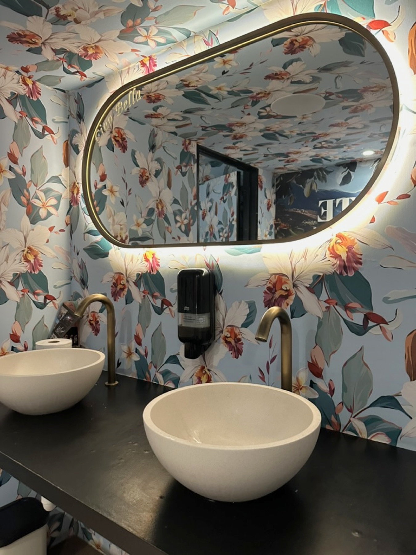Toiletruimte met botanisch behang en verlichte spiegel