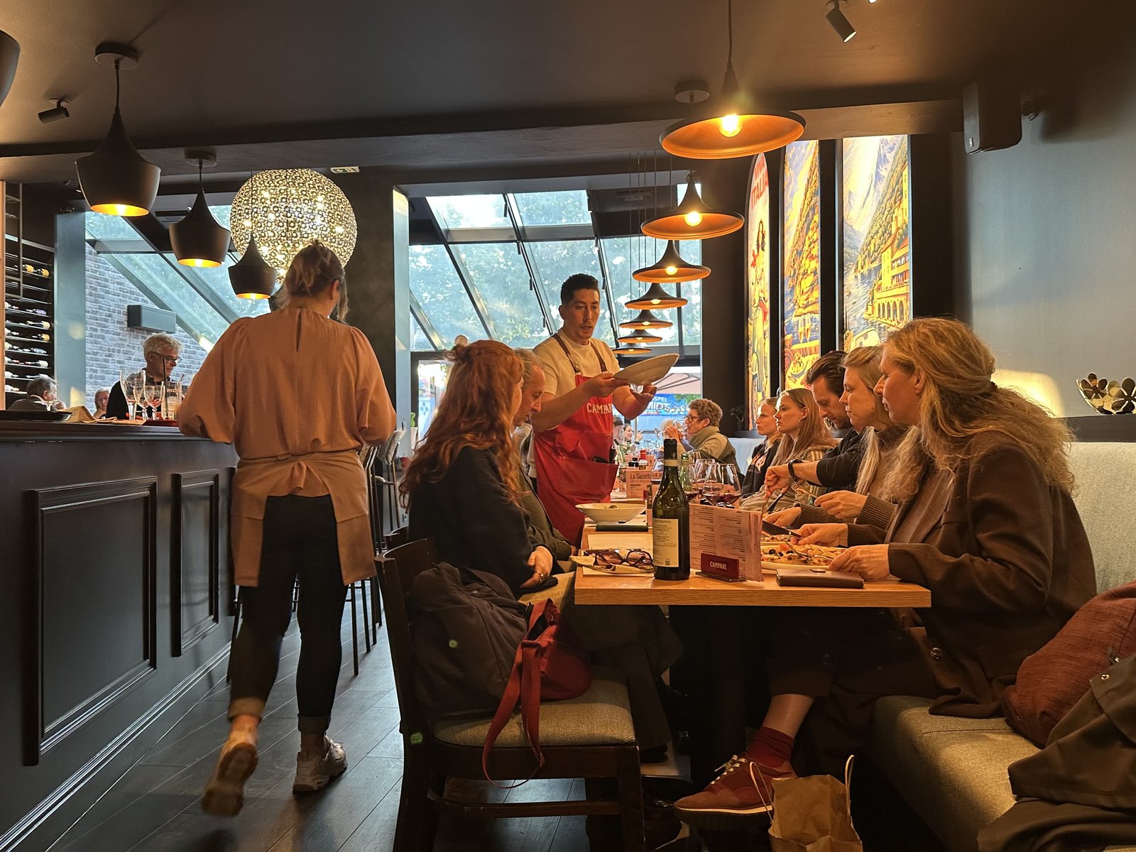 Bediening aan tafel in een gezellige, drukke zaal